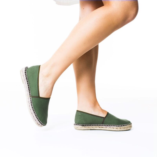 Arme gröna espadriller med vit klänning och bara ben